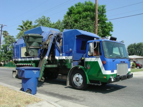 Workers loading waste into a skip